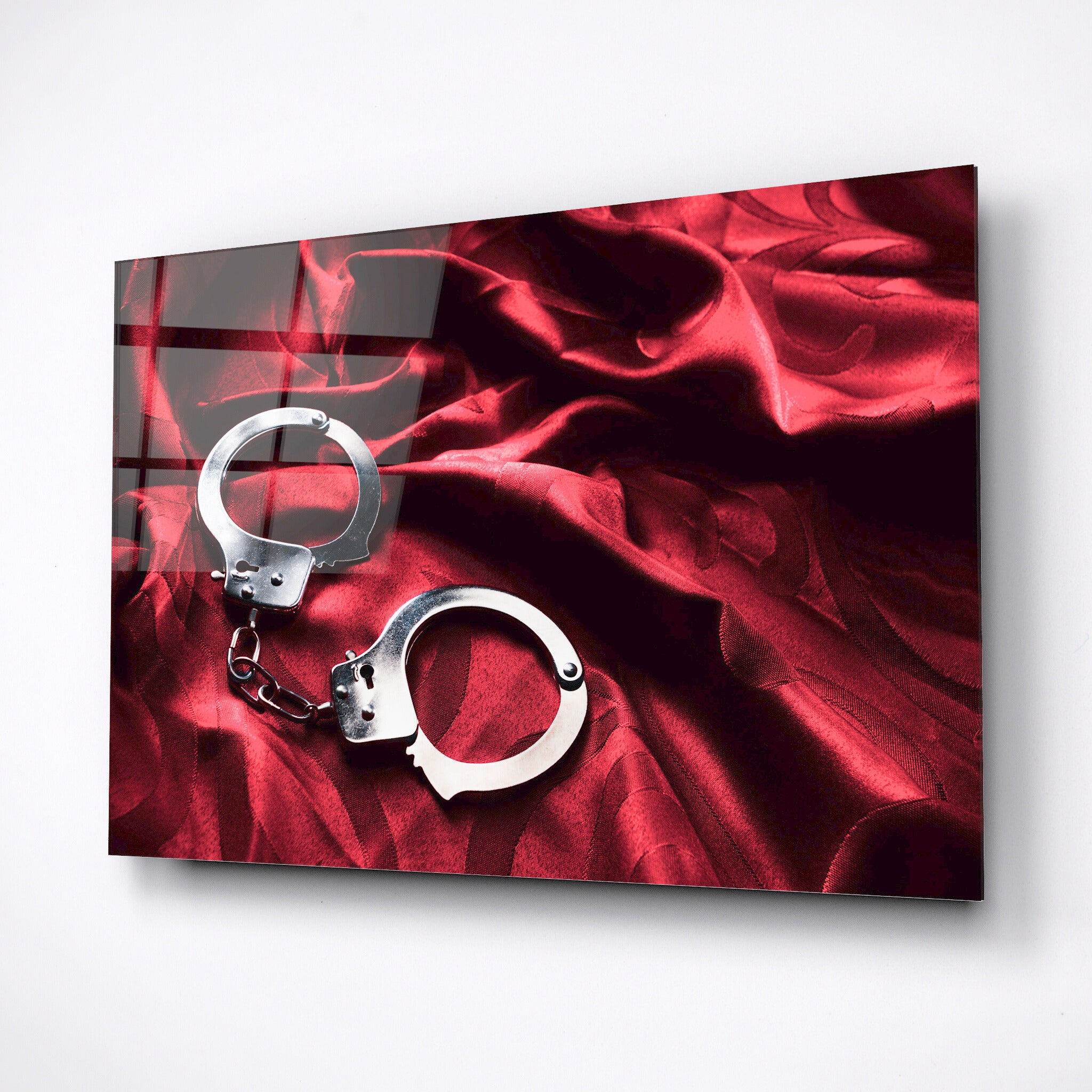 handcuffs on a red bed sheet wall art decor